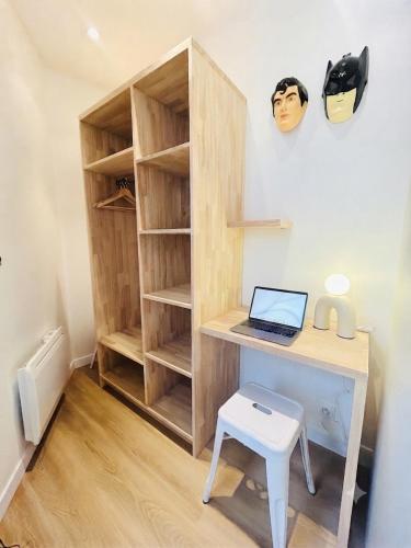 a desk with a laptop and a stool at Le Goldorak, Hyper-centre, Garage privé, CLIM et canal plus in Niort