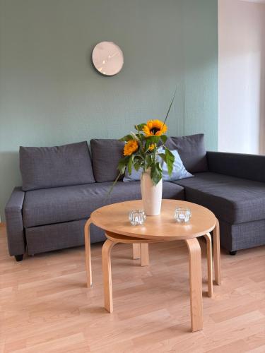 a living room with a couch and a table with a vase of flowers at Hotel Am Mühlenteich in Lübeck