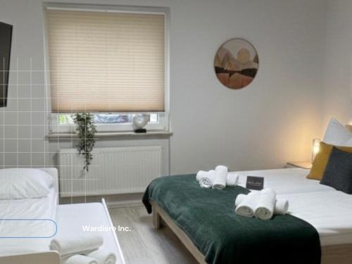 a bedroom with a bed with two towels on it at Wellness -Residenz Ehrhardt Urlaub mit Pool und Garten Ferienwohnung im Herzen von Halberstadt in Halberstadt