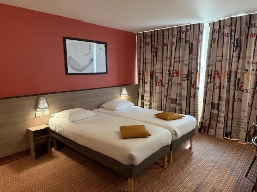 a bedroom with a large bed with red walls at Hôtel Goodwood Caen Mémorial in Caen
