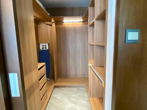a walk in closet with wooden cabinets and a blue object at High Class 1BR at One Euphoria in Angeles