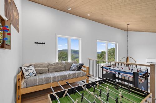 a living room with a couch and a ping pong table at Apex Nuage - Spa Game Room & Panoramic Views in Saint Come