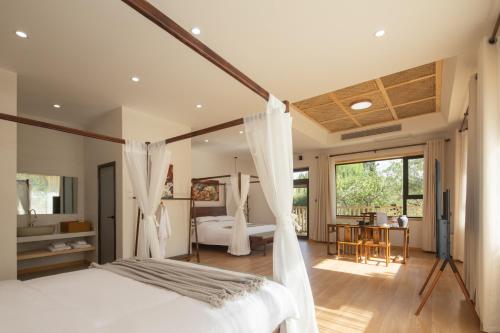 a bedroom with a white bed and a table at Dunhuang County Posthouse in Dunhuang