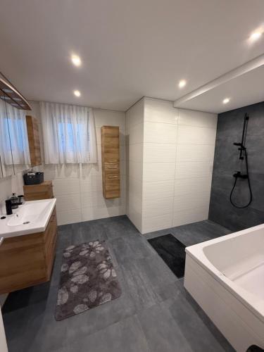a bathroom with a tub and a sink and a bath tub at Wohnung im Grünen in Sankt Andrä