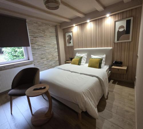 a bedroom with a large white bed and a chair at Jardin De Pairis in Orbey