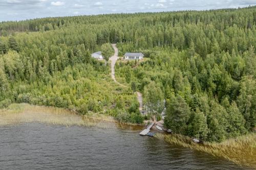 an aerial view of a house on an island in the water at Villa Vilkama 2 cabins Lake view, incl indoor hot tub, sauna in Laukaa