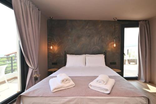 a bedroom with a bed with two towels on it at Liostasi Villas by Olga in Leptokarya