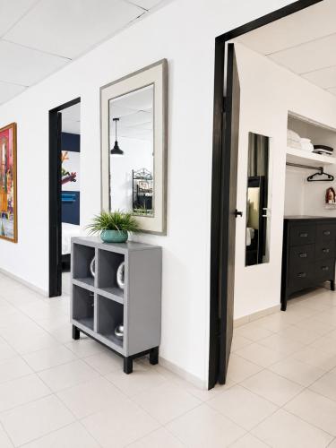 a hallway with a mirror and a cabinet with a plant at OJAS Local Nest in San Juan