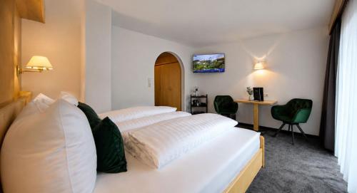 a hotel room with two beds and a desk at Garni Rustica in Sölden