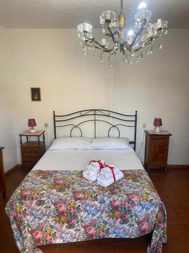 a bedroom with a bed with towels and a chandelier at La chiesina delle conce in Sarteano