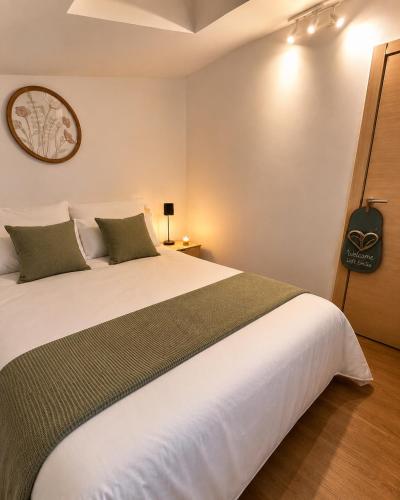 a bedroom with a large white bed with green pillows at LOFT EMILIA - la tappa perfetta tra Bologna e Ravenna - SELF CHECK-IN in Castel Bolognese