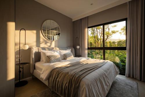 a bedroom with a large bed and a large window at Luxury 2 bedroom pool access apartment in Bang Tao Beach