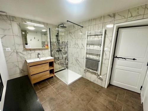 a bathroom with a shower and a sink and a mirror at Gite Maison Saint-Martin in La Groise