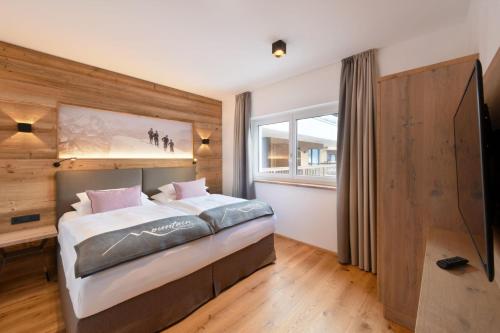 a bedroom with a bed and a large window at Venediger Lodge in Neukirchen am Großvenediger