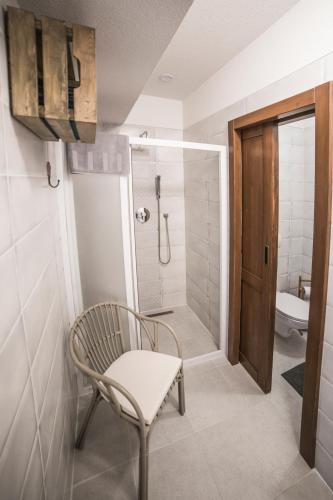 a bathroom with a chair and a shower at Apartmán Chopok Juh Romantika 14 in Tale