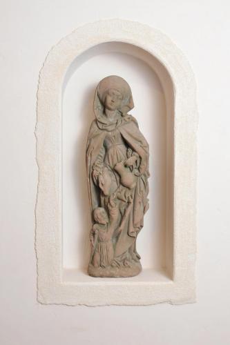 a statue of a woman holding a baby on a wall at Hotel Deutsches Haus in Dinkelsbühl