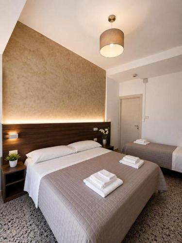 a bedroom with a large bed with towels on it at HOTEL TRIESTE in Riccione