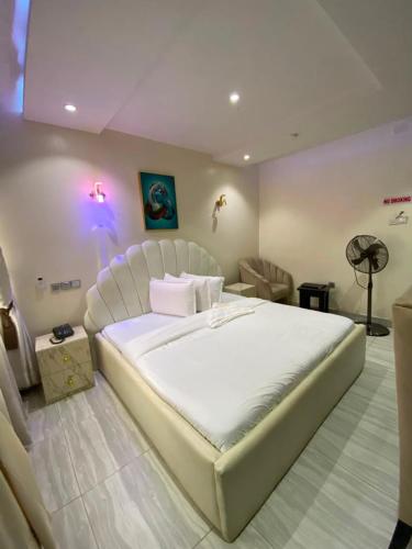a bedroom with a large white bed in a room at S&B Hotel in Agege