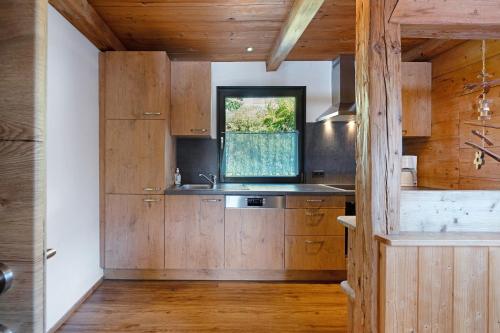 a kitchen with wooden cabinets and a window at Ferienhaus Anton in Gerlosberg