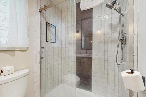 a white bathroom with a shower and a toilet at Sanctuary on Park Ave in Hawley