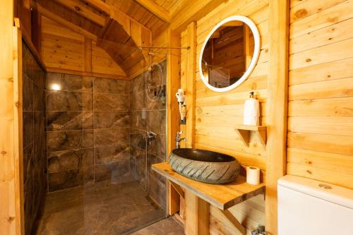 ein Badezimmer mit Waschbecken und Dusche in einer Blockhütte in der Unterkunft Flavia Hotel in Kızılcakaya