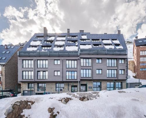 a large building with snow on the roof at Estival Caribou Apartments in Pas de la Casa