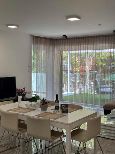 a dining room with a table and chairs and a large window at BB Riviera Resort in Balatonboglár