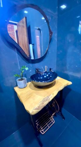 a bathroom with a mirror and a blue wall at Cabaña Premium Yvyja de La Mala Junta in Atyrá