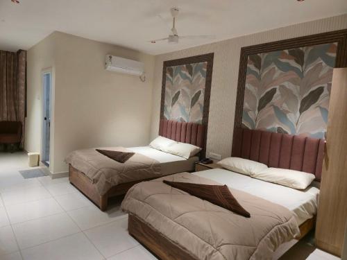 a hotel room with two beds and a painting on the wall at Hotel Royal Akkamahadevi in Sundi Penta
