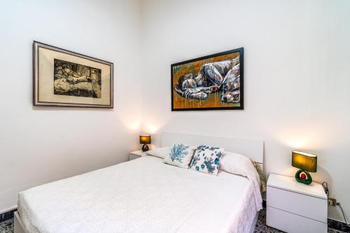 a bedroom with a bed and two pictures on the wall at Al Portico in Avola