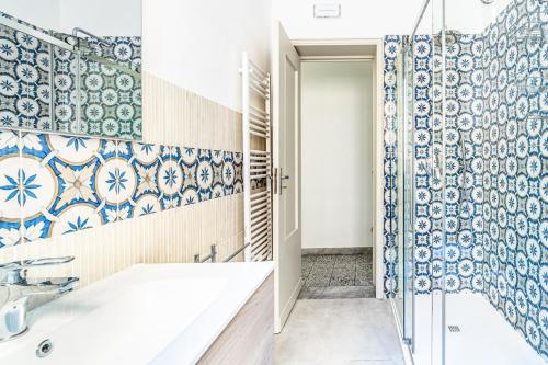 a bathroom with blue and white tiles on the wall at Al Portico in Avola