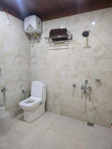 a bathroom with a toilet and a shower at Hotel Royal Akkamahadevi in Sundi Penta