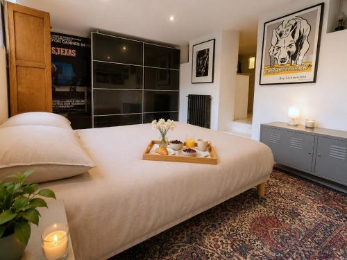 a bedroom with a large bed with a tray of fruit on it at Villa Georges in Issy-les-Moulineaux