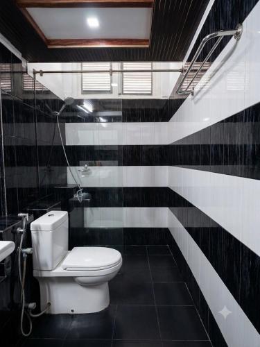 a black and white bathroom with a toilet and a sink at Subhas Tourist Hotel in Jaffna