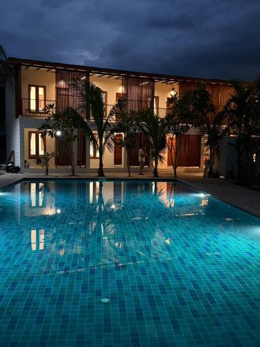 a large blue swimming pool at night at Mountainblues Hotel in Pai