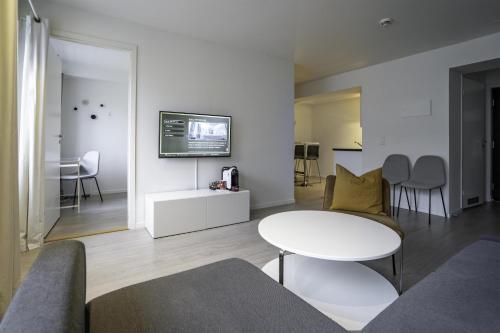 a living room with a table and a tv on a wall at Magic Kloverhuset Harbour Hotel, a member of Radisson Individuals in Bergen