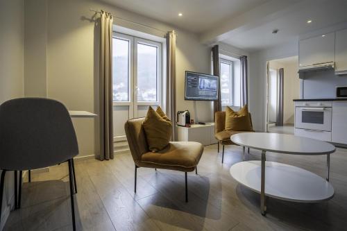 a living room with a table and chairs and a kitchen at Magic Kloverhuset Harbour Hotel, a member of Radisson Individuals in Bergen
