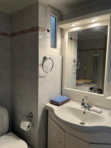 ein Badezimmer mit Waschbecken, Spiegel und Toilette in der Unterkunft Brillarooms in Rethymno
