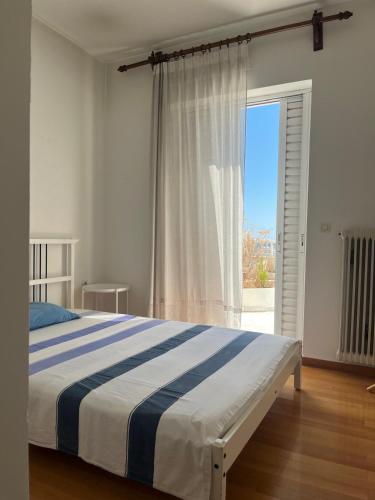 ein Schlafzimmer mit einem Bett und einem großen Fenster in der Unterkunft Brillarooms in Rethymno