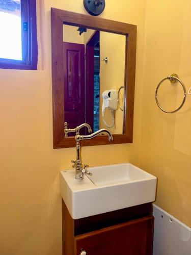 a bathroom with a white sink and a mirror at Volissos Pirgos Village in Volissos