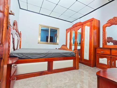 a bedroom with a wooden bed and a dresser at Keitaya Dubreka Guinea in Conakry