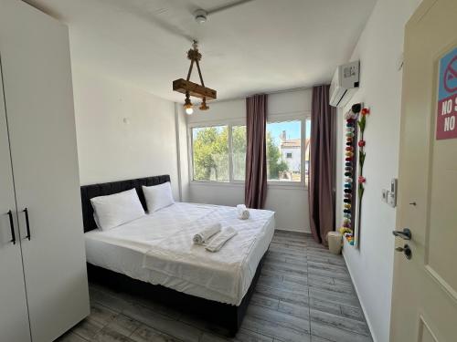 a bedroom with a bed and a window at Hotel Buse in Alaçatı