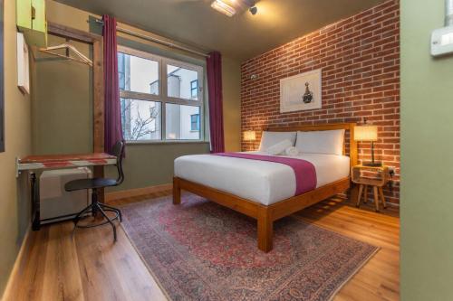 a bedroom with a bed and a brick wall at The Nest Boutique Hostel in Galway