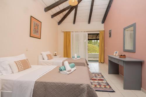 a bedroom with two beds and a desk in it at Sunrise Stone Villa in Agios Nikolaos