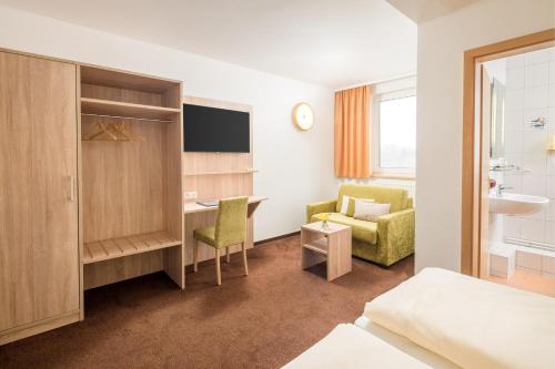a hotel room with a bed and a desk and a chair at Lübsche Thorweide in Wismar