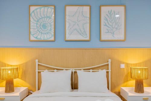 a bedroom with a bed with three pictures on the wall at Bocage Blue Heaven I, By Home Match in Setúbal
