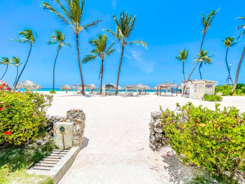 a white sandy beach with palm trees and umbrellas at Los Corales CASAS DE LAS TERRAZAS Bavaro POOL VIEW HOTEL Bavaro Beach CLUB & SPA in Punta Cana