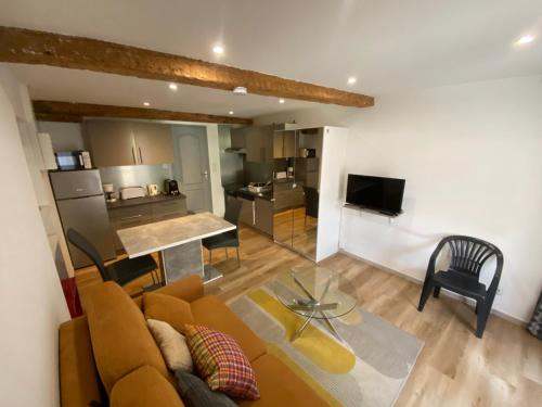 a living room with a couch and a kitchen at Orry d'Oriège in Ax-les-Thermes