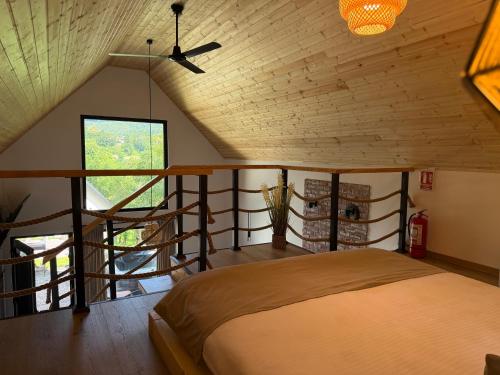 a bedroom with a bed and a spiral staircase at Kolibe Doftana in Trăisteni