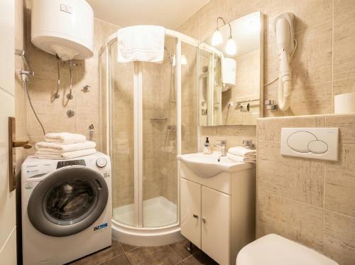 a bathroom with a washing machine and a washer at Green Garden Gajac in Gajac